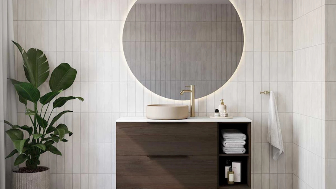 Standard baderom med møbel i mørk ask, rundt speil med lys